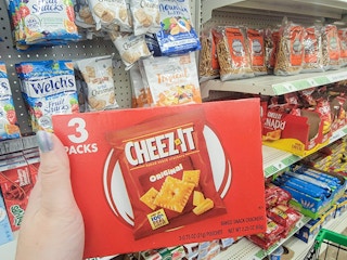 hand holding a box of 3 packs of cheez its crackers