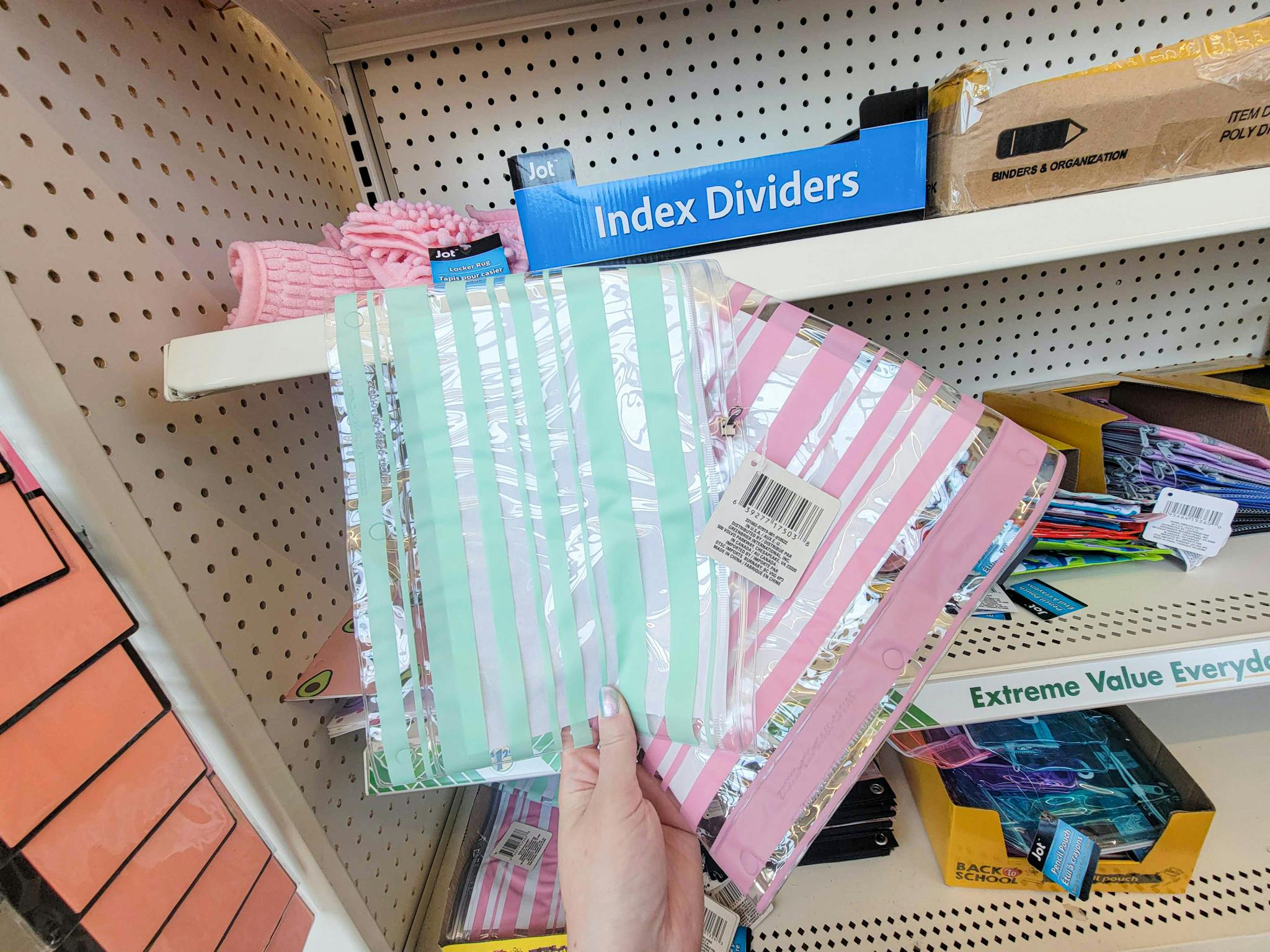 hand holding 2 clear striped pencil pouches, one has green stripes one has pink stripes