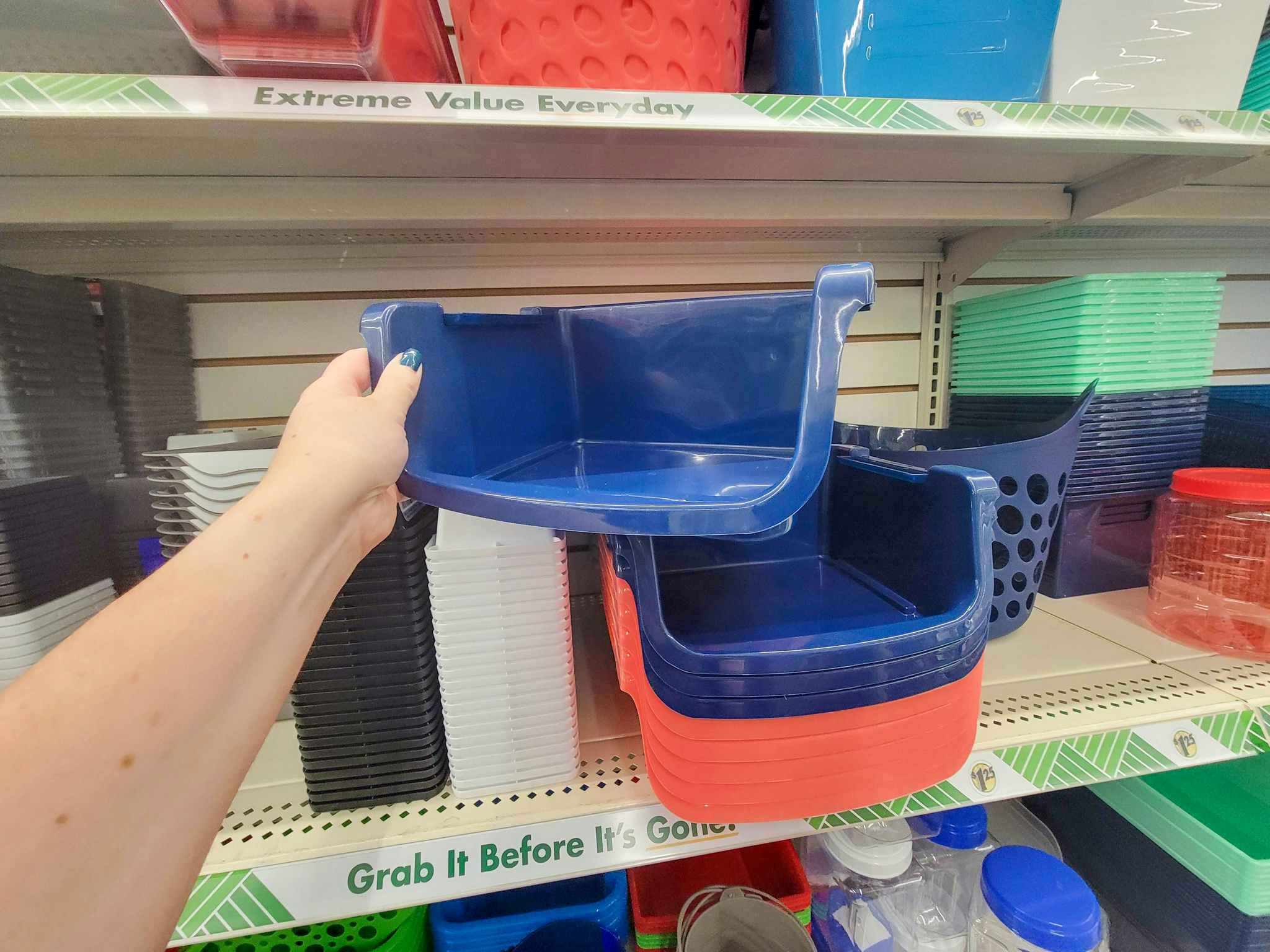hand holding a navy blue stackable storage bin