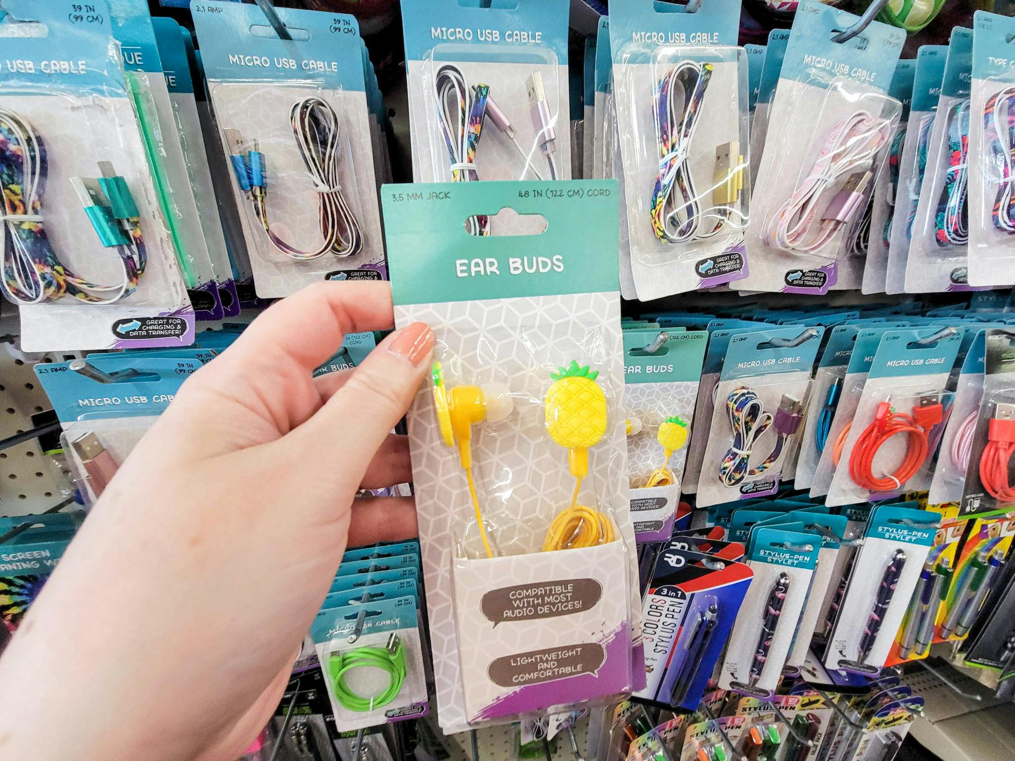 hand holding up a pair of pineapple ear buds