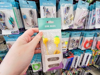 hand holding up a pair of pineapple ear buds