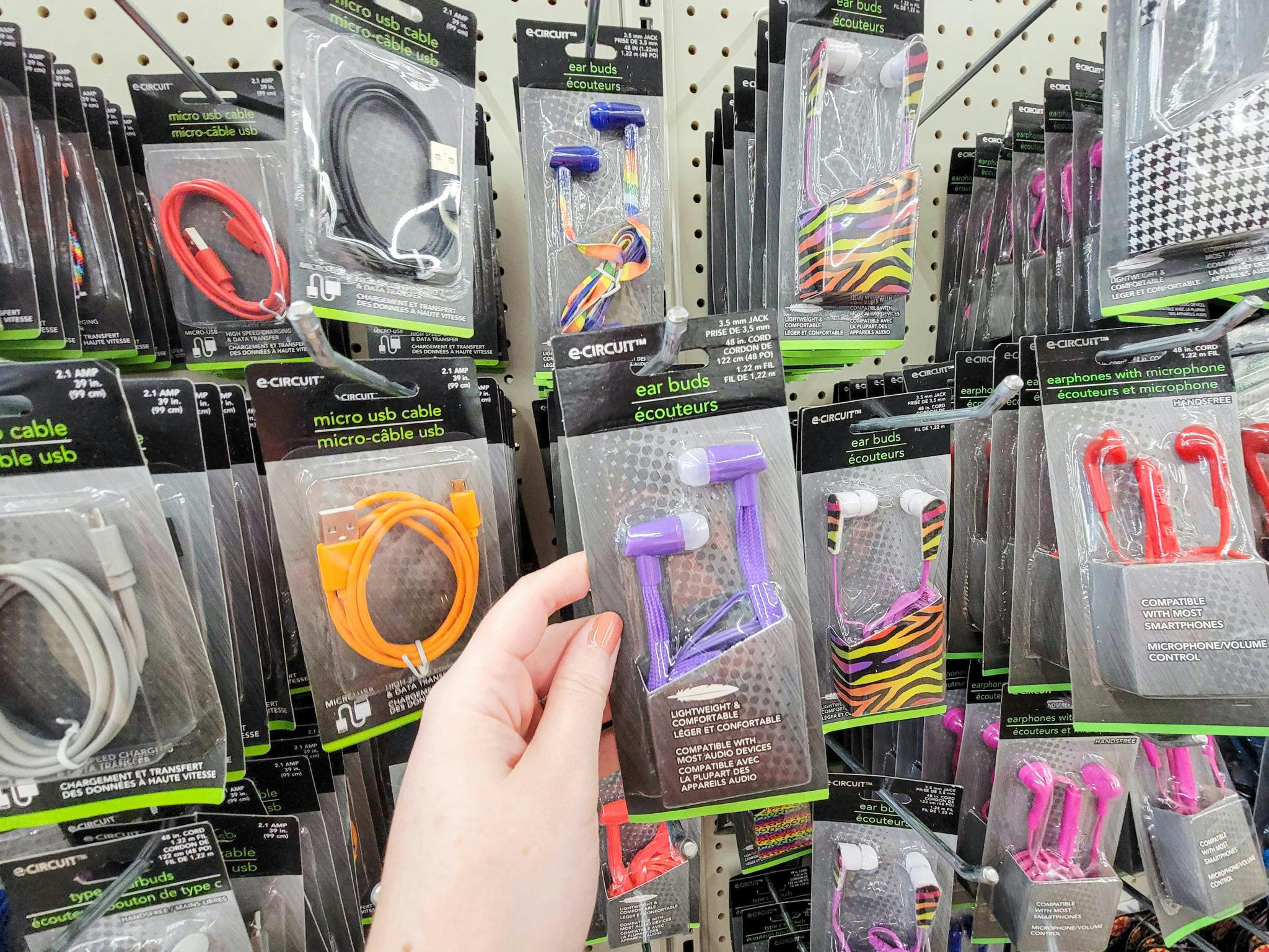 hand holding a pair of purple ear buds