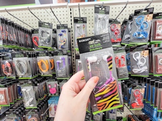 hand holding a pair of zebra printed rainbow colored ear buds