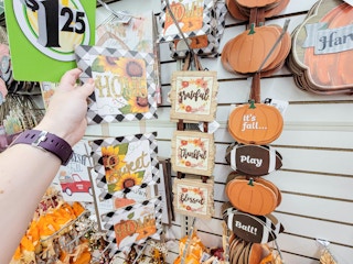 hand holding a hanging home sweet home fall sign by a grateful thankful blessed sign