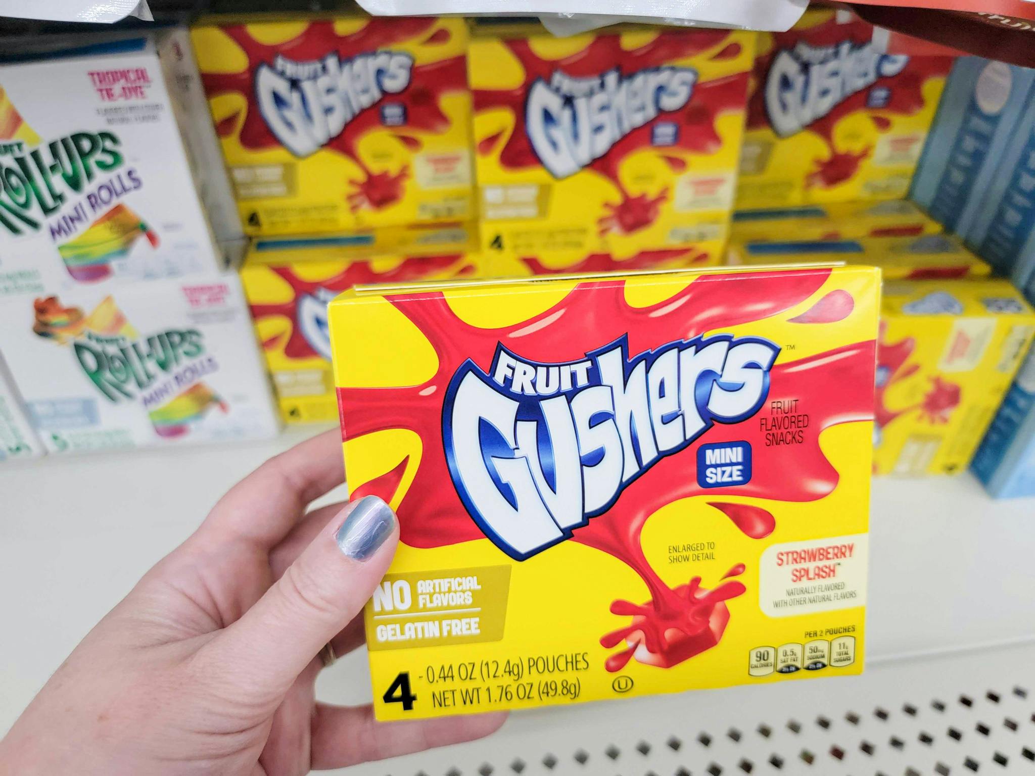 hand holding a box of gushers fruit snacks