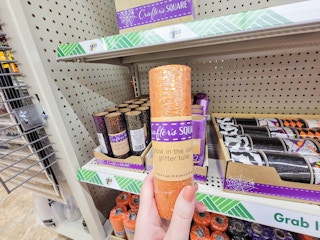 hand holding a pack of orange glow in the dark tulle