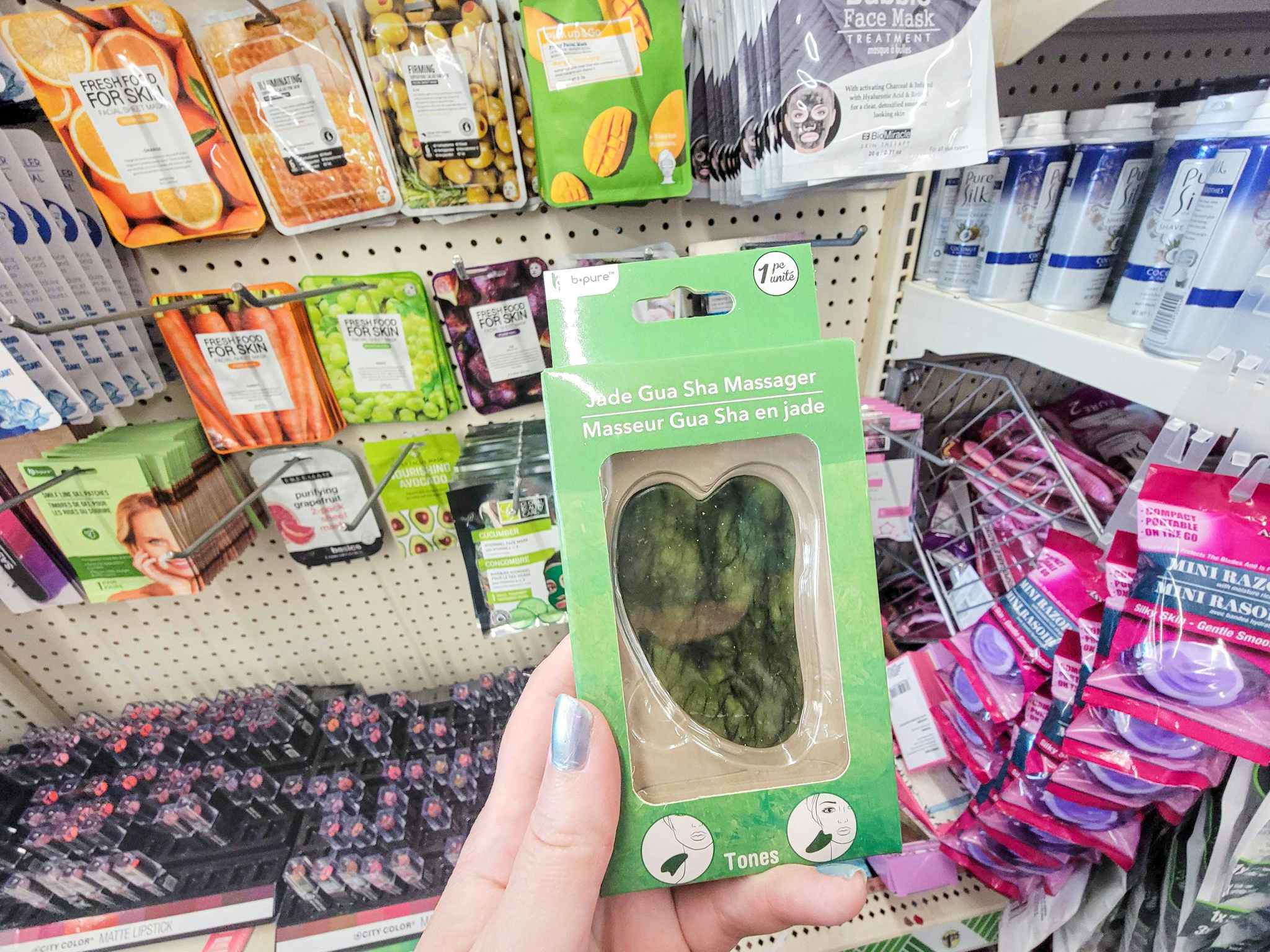 hand holding a jade gua sha massager