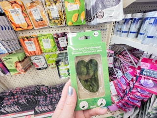 hand holding a jade gua sha massager