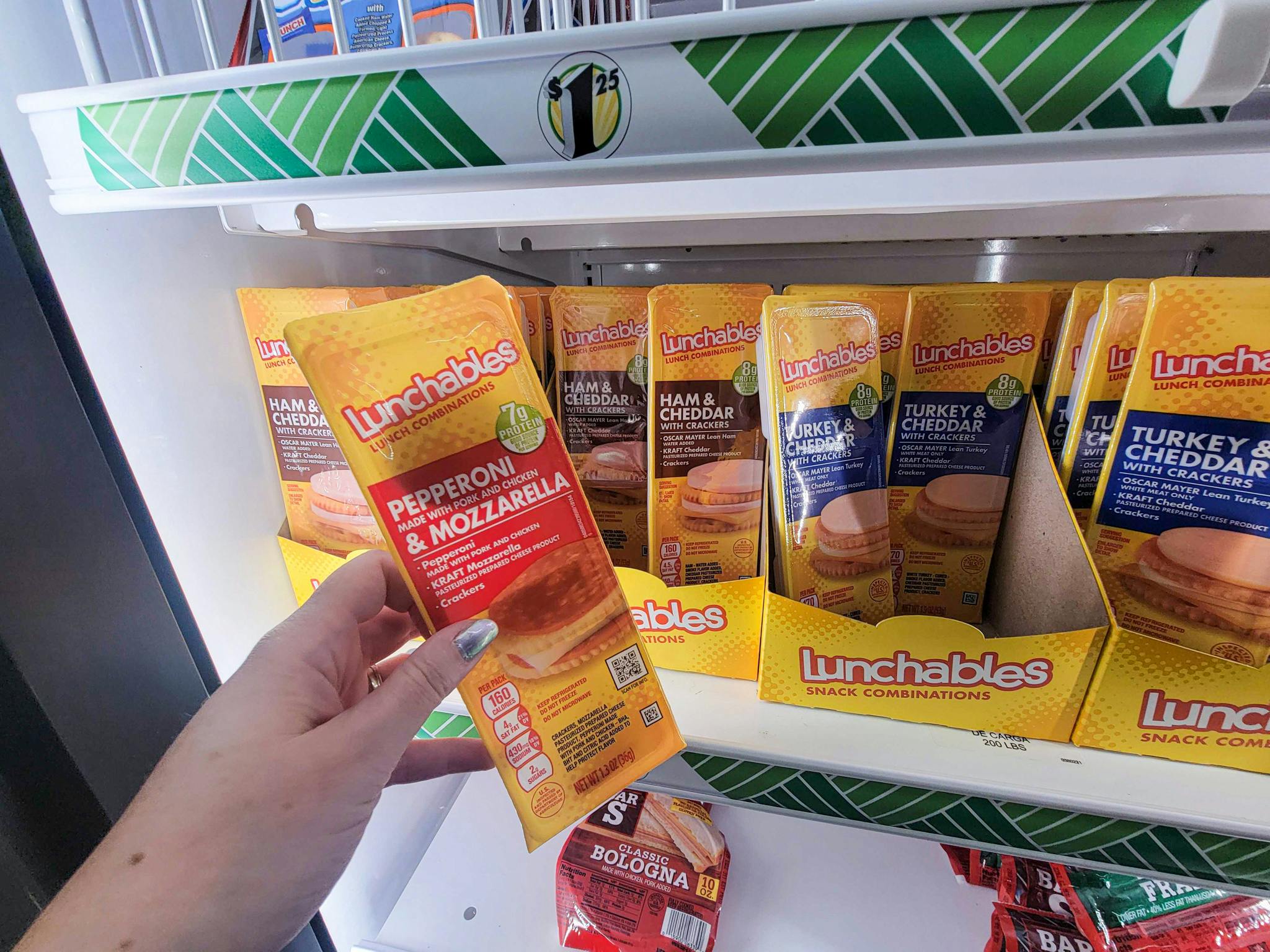 hand holding a pizza lunchable in front of cracker stacker lunch ables