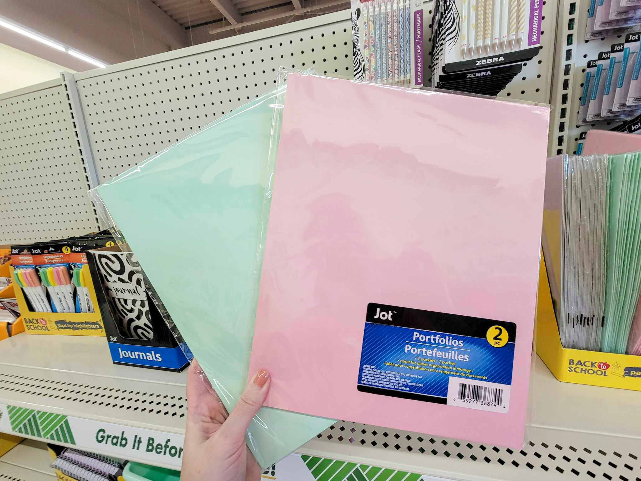 hand holding 2-packs of pastel folders