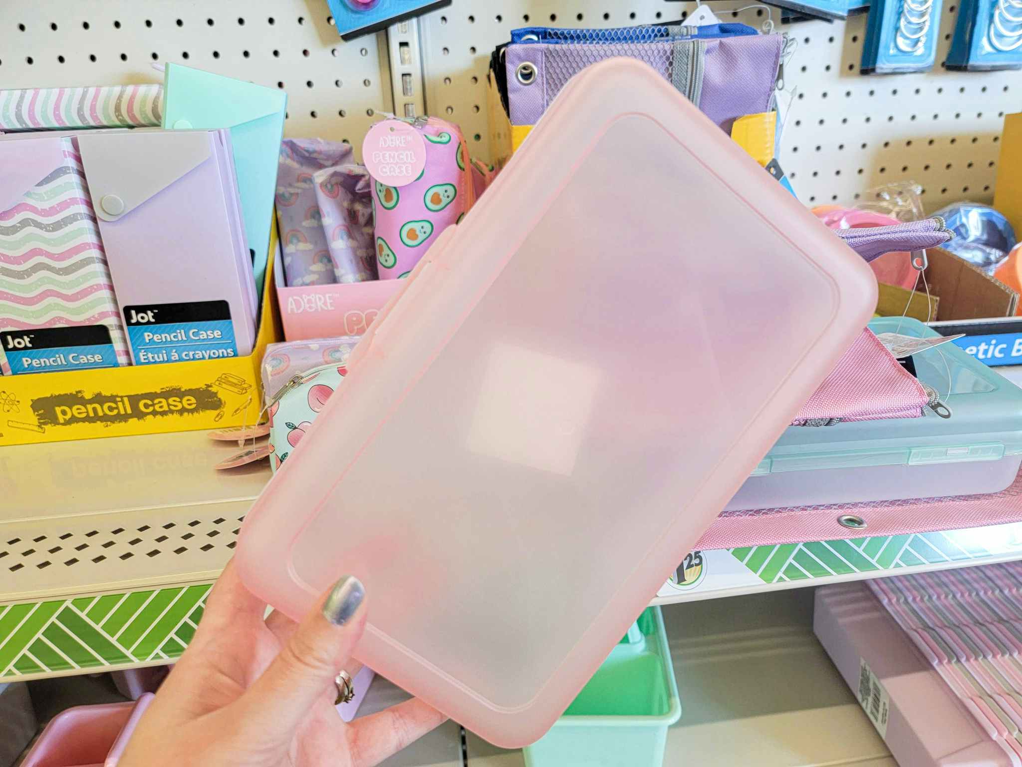 hand holding a pink translucent plastic pencil box