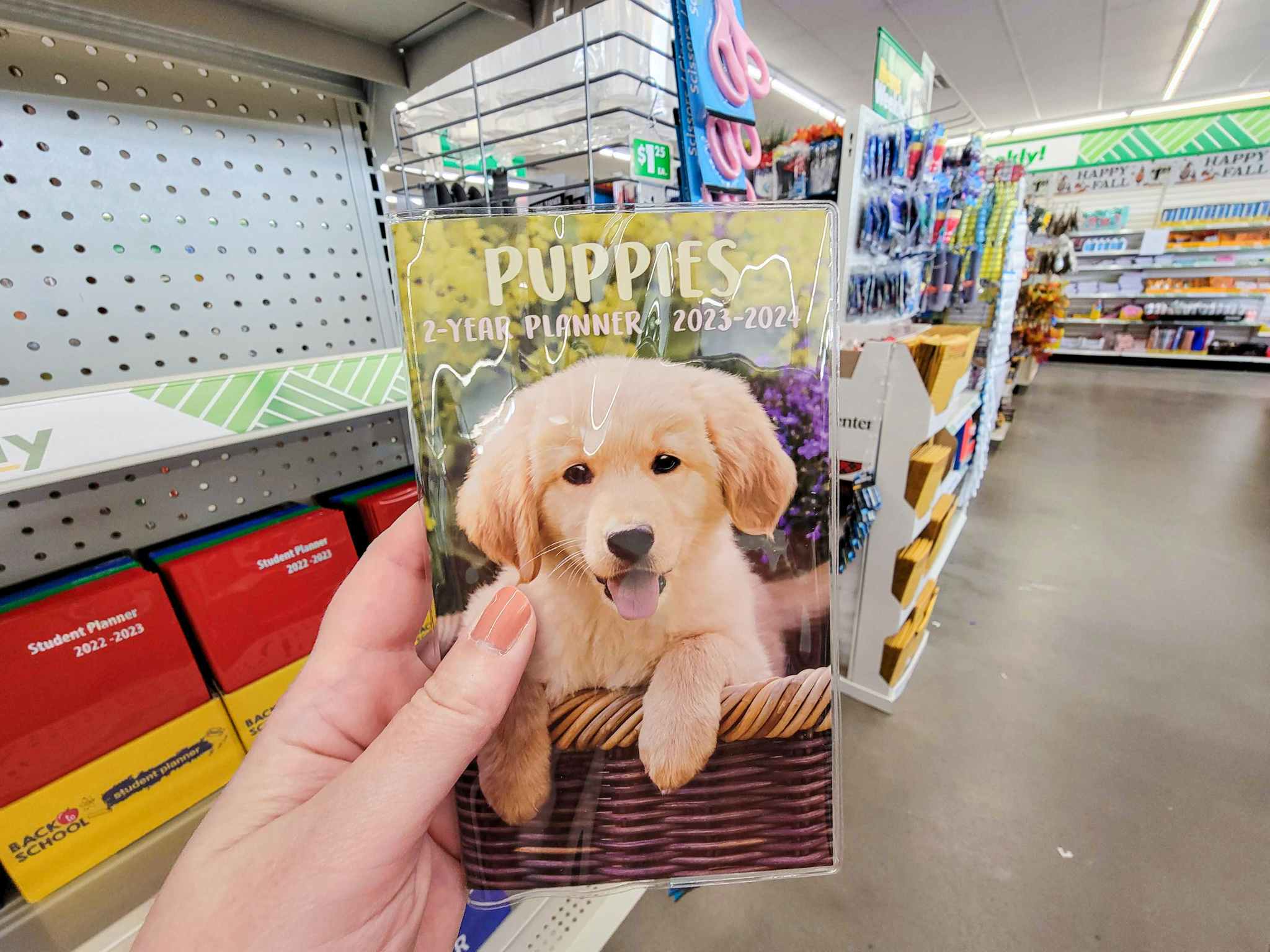 hand holding a 2023-2024 planner with a puppy on it