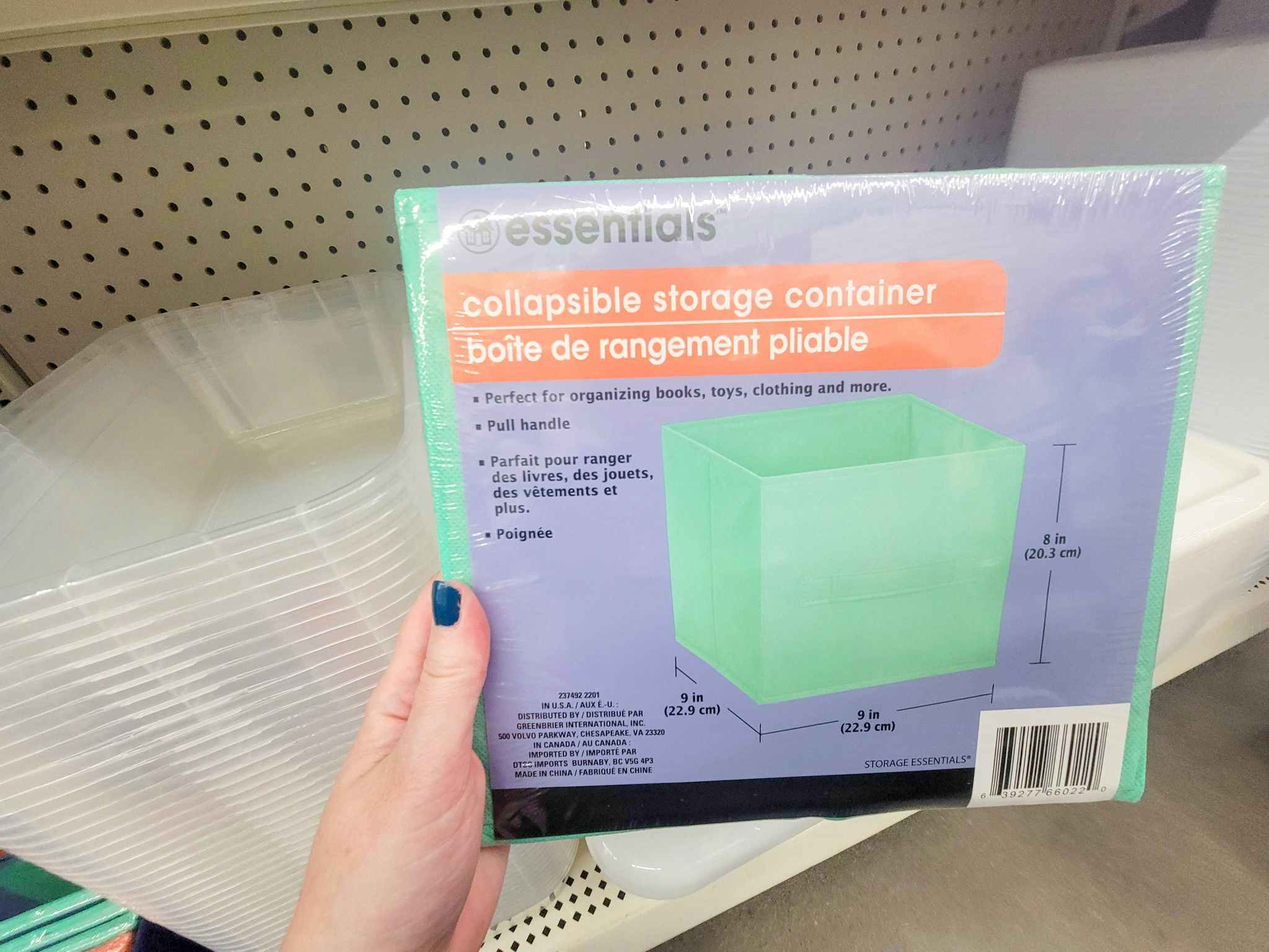 hand holding a mint colored collapsible storage container