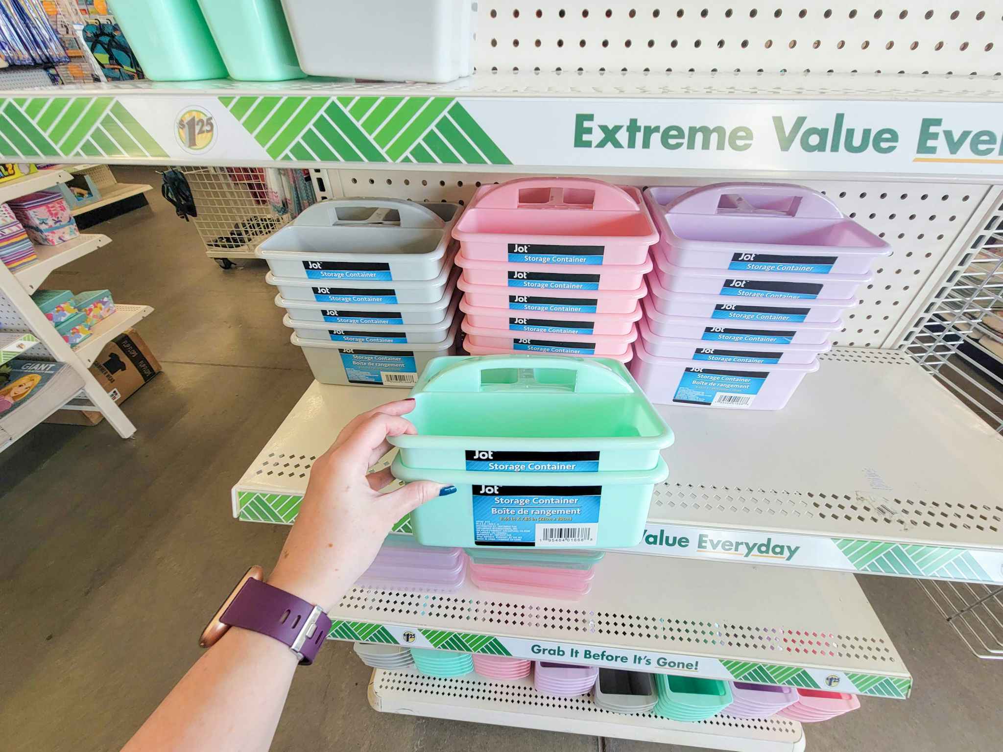 hand holding storage containers that are mint green in front of other pastel colored storage containers