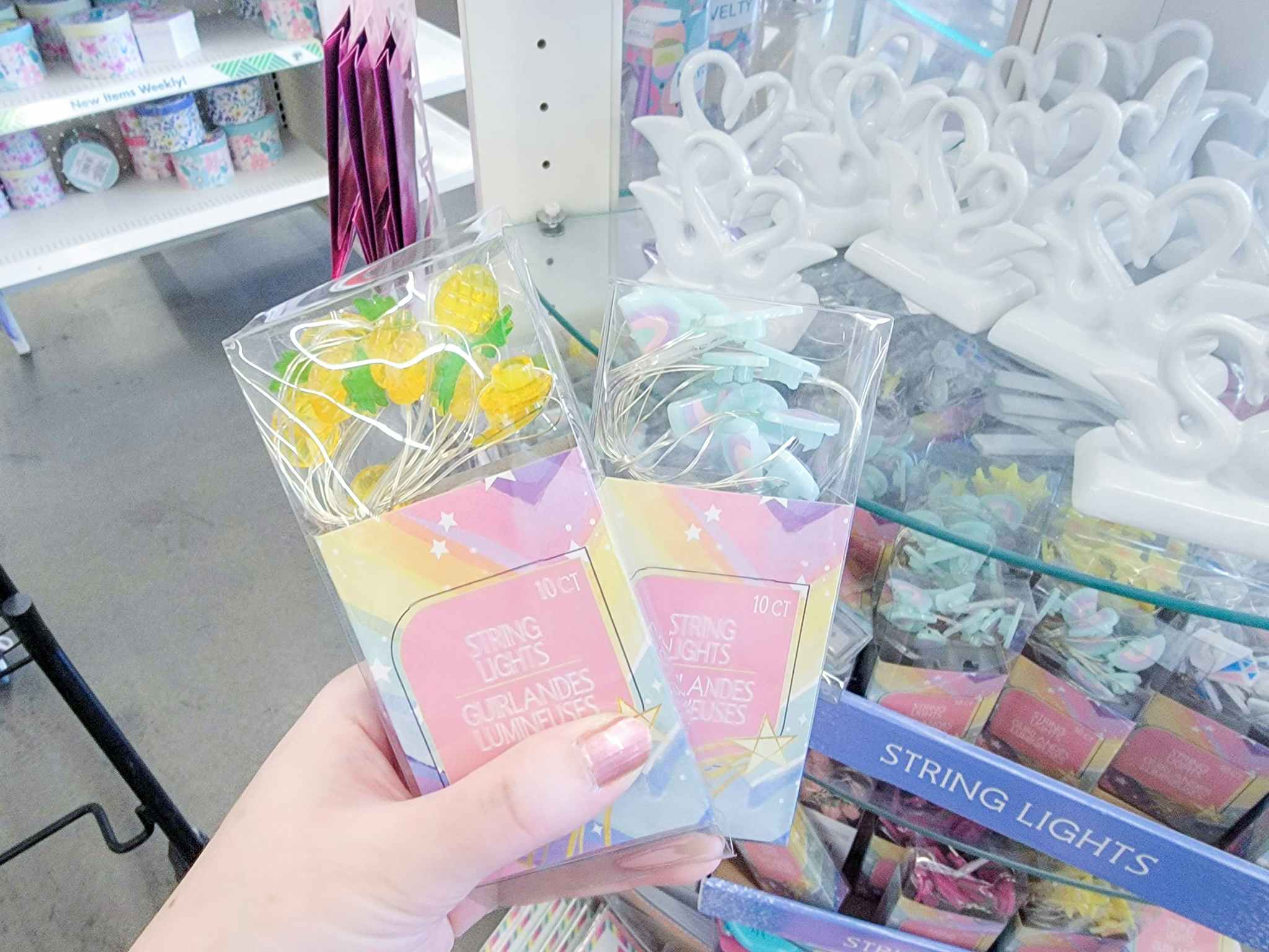 hand holding rainbow and pineapple string lights