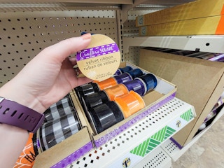 hand holding a roll of velvet craft ribbon