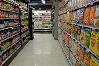 a supermarket aisle with no people in it with the lights dimmed after hours