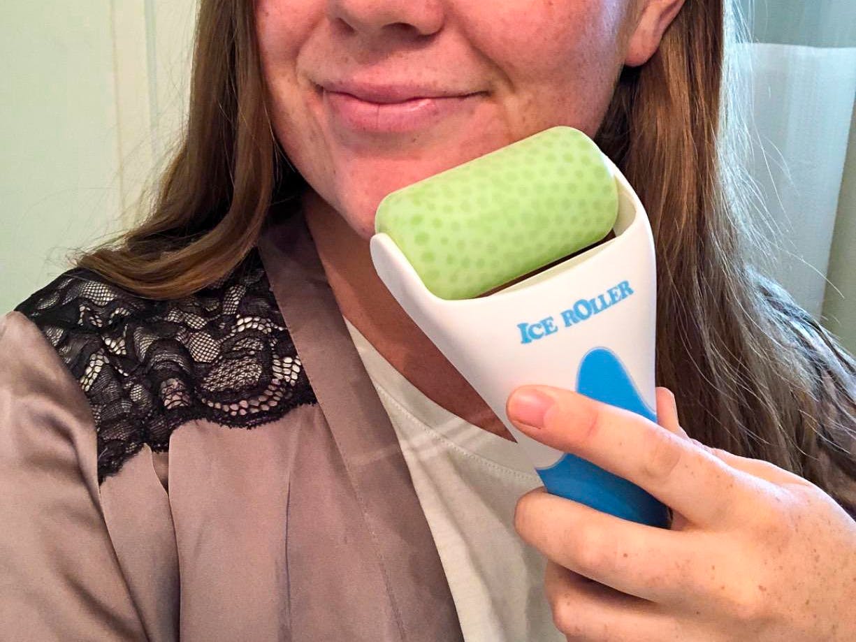 A woman using an Esarora ice roller on her face.