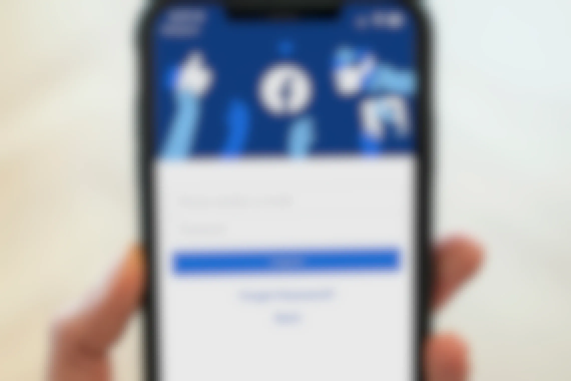 person holding iphone with facebook login page on screen