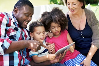 family watching tablet on outdoor swing