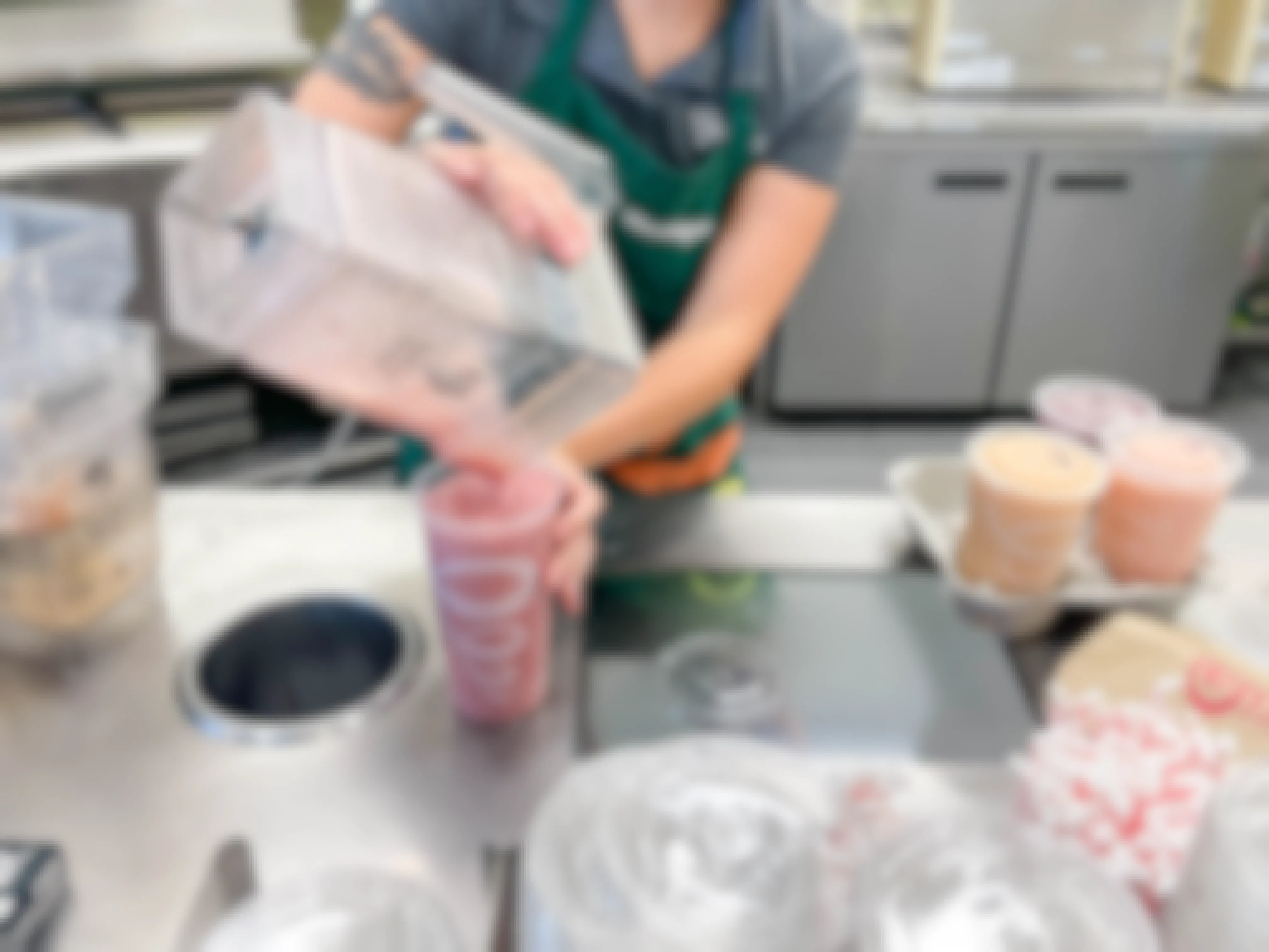 employee pouring jamba juice smoothie into large cup 