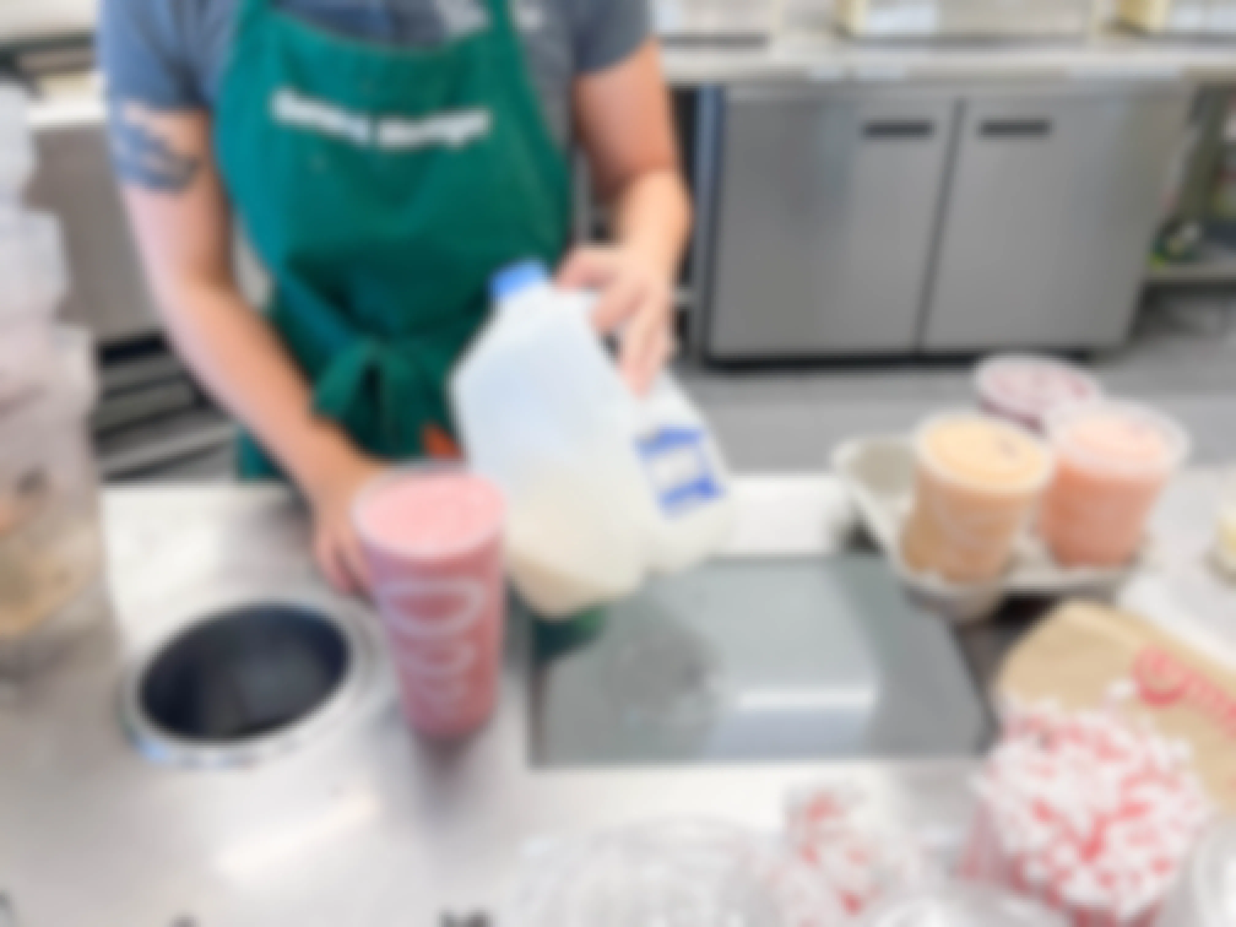 employee holding milk next to smoothie 