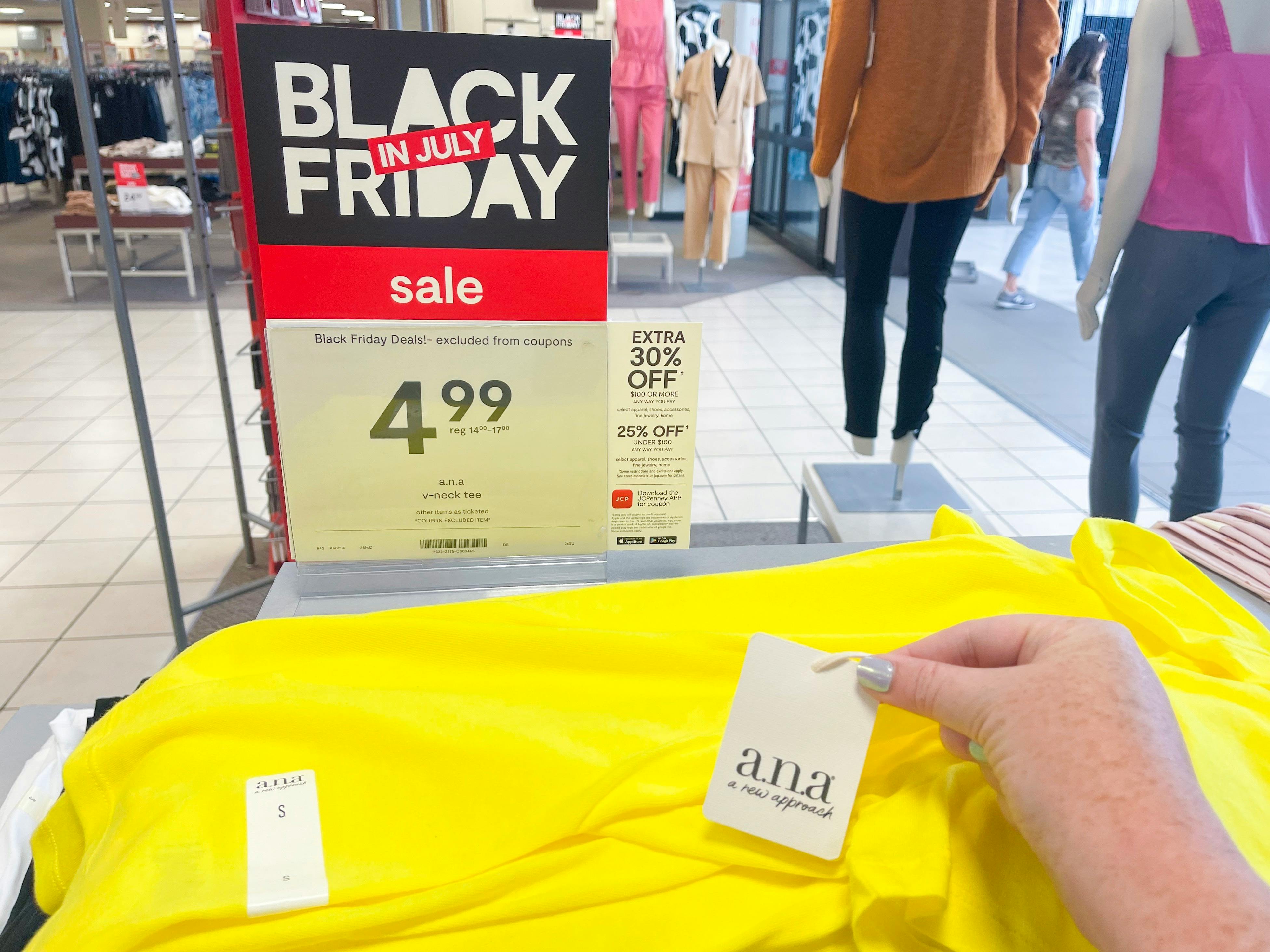 ana tee-shirt on black friday in july sale with shirt tag being held up