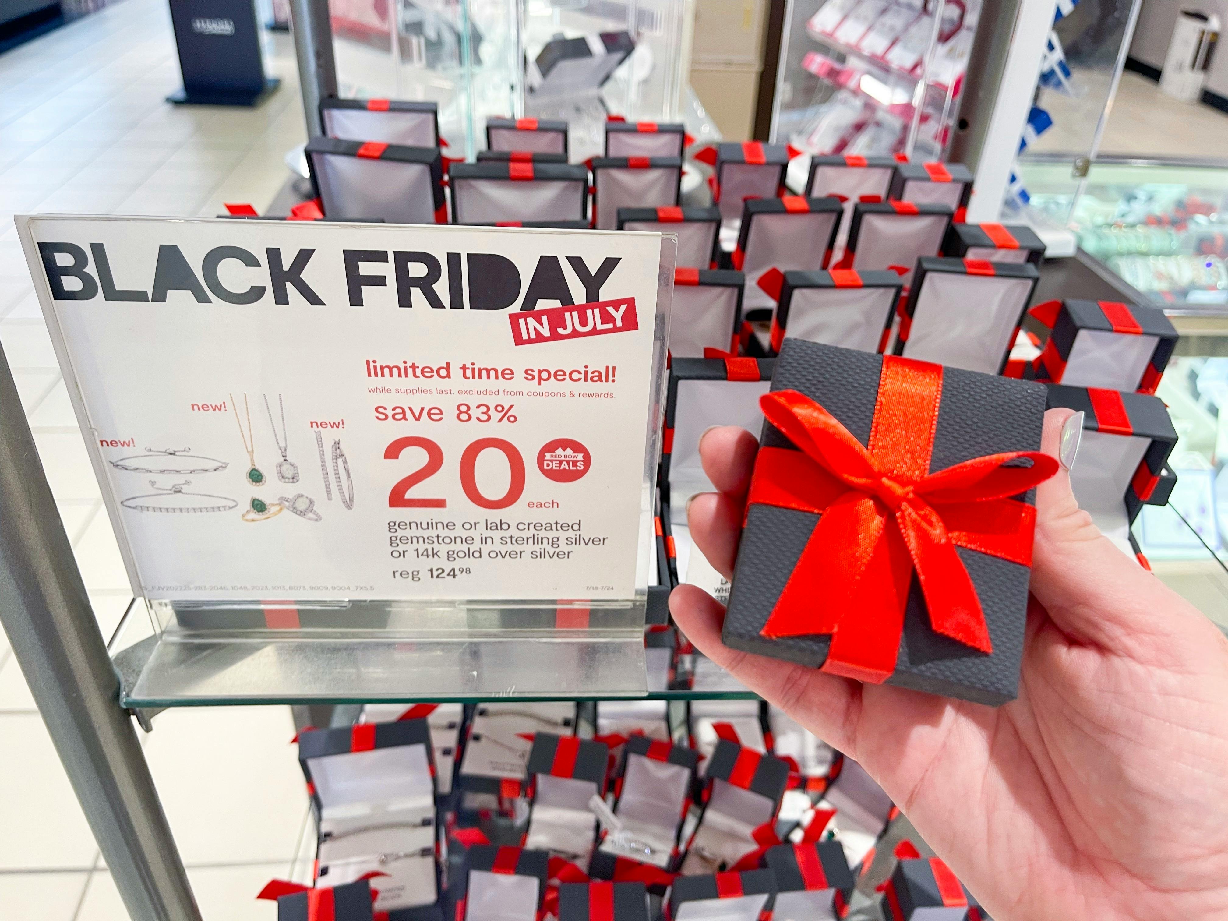 a jewelry box being held in front of jewelry stand with black friday in july sign