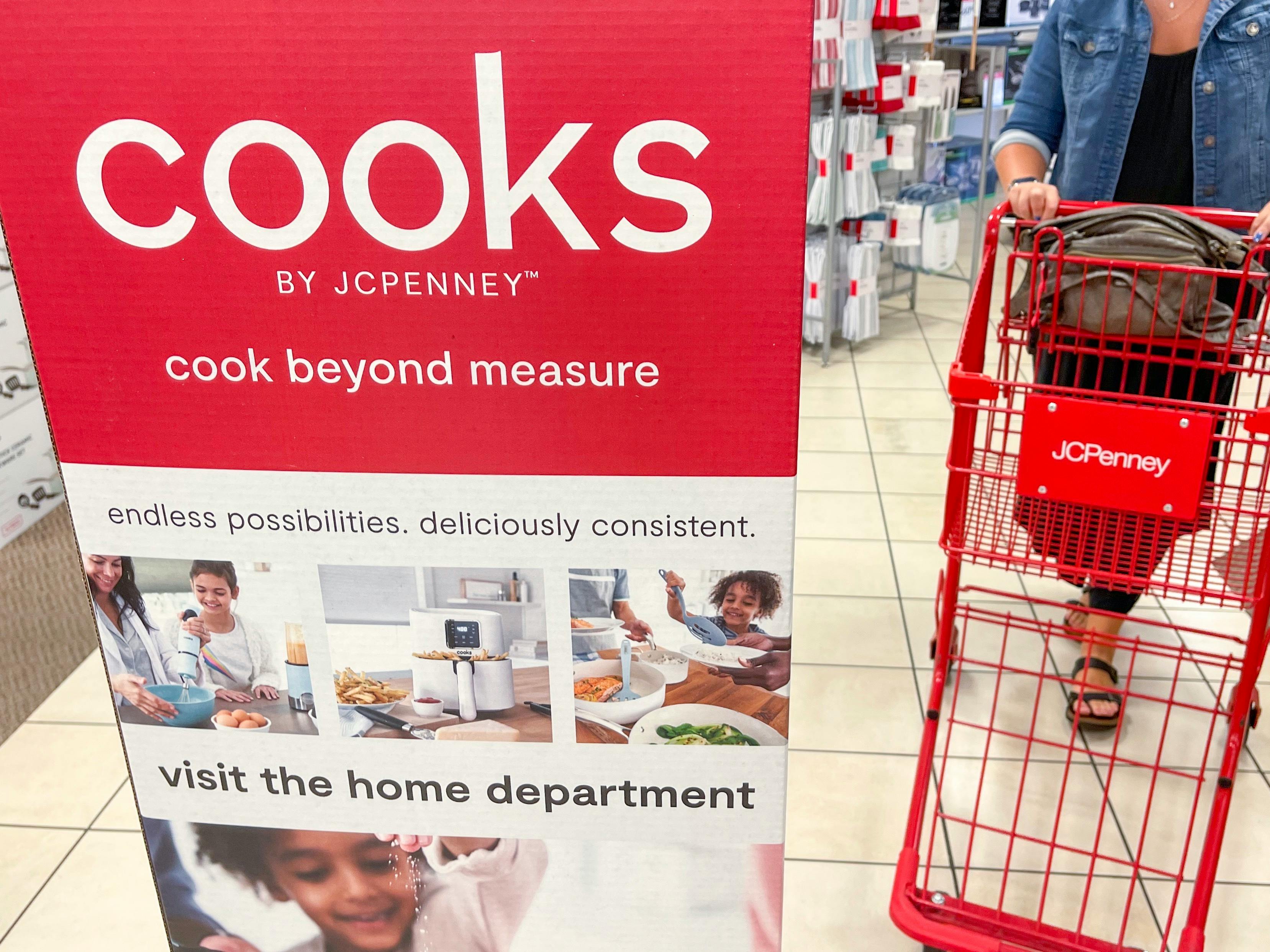 cooks display sign in aisle with jcpenney cart being pushed down aisle