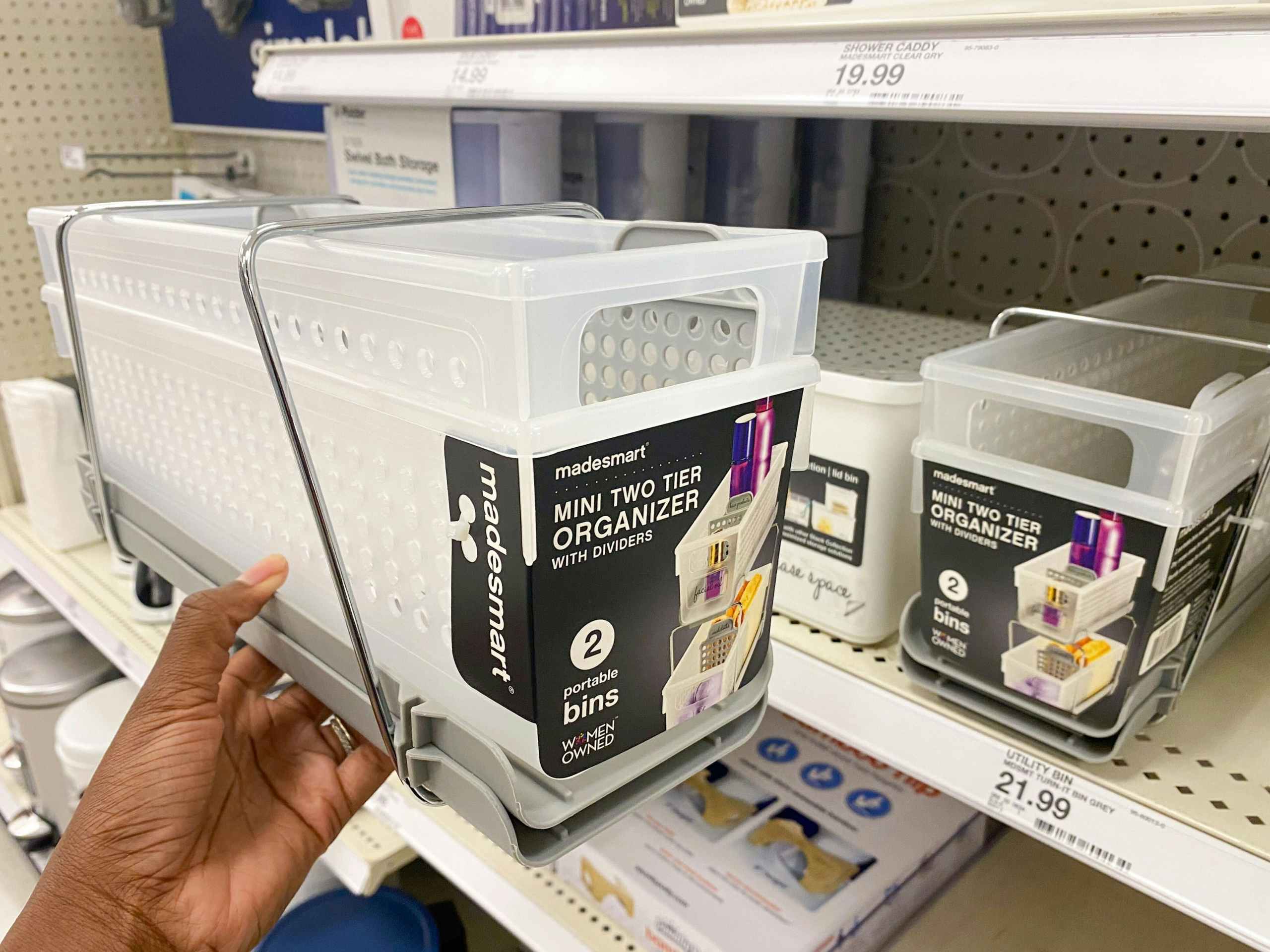 hand holding a madesmart mini two-tier organizer with dividers in front of a target shelf