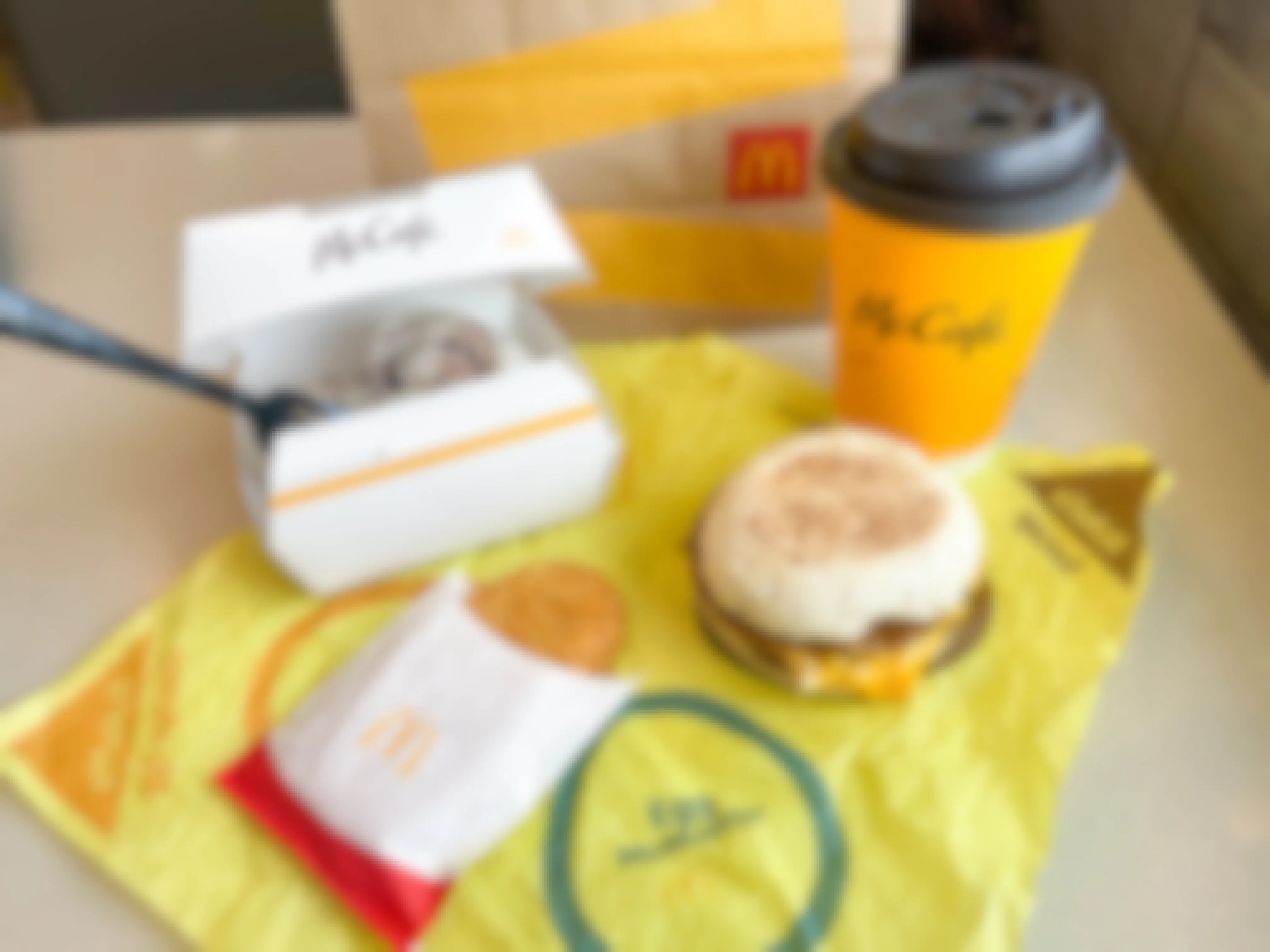 mcdonalds cinnamon roll, mcgriddle, hashbrown, and coffee breakfast on wrapper with bag