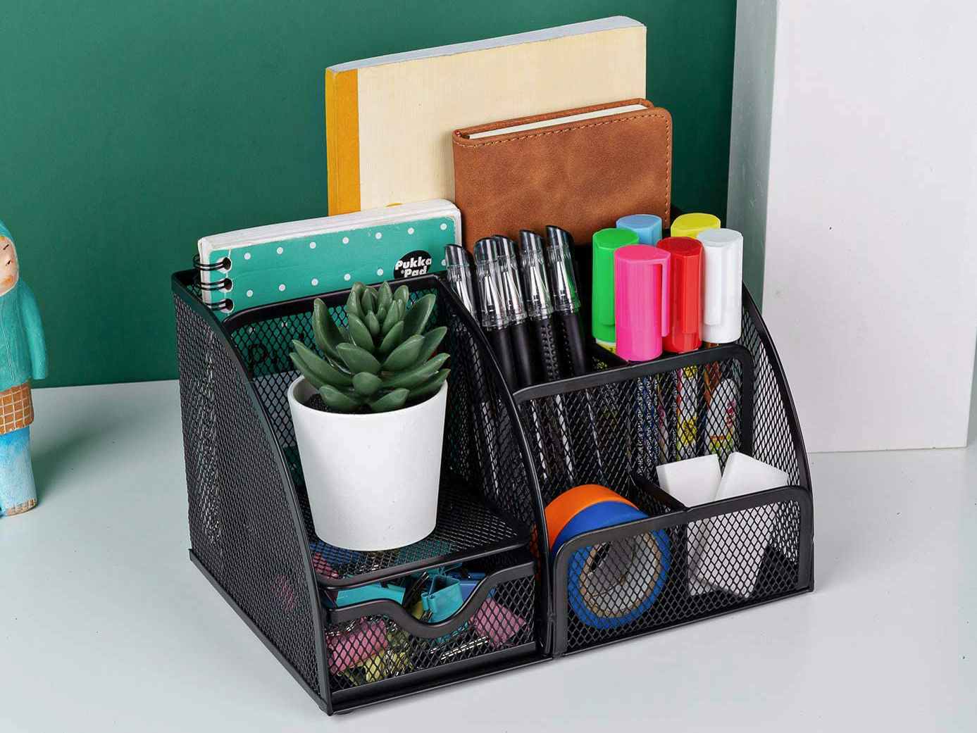 A mesh metal office desk organizer from Amazon, sitting on a desk.