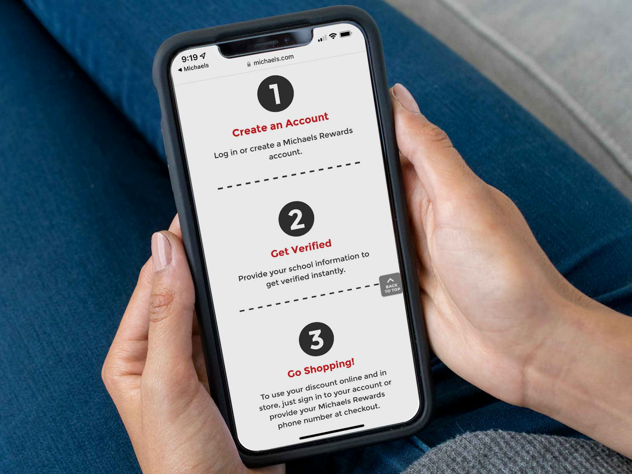 A person holding an iPhone displaying the instructions for Teacher Verification on the Michaels website.