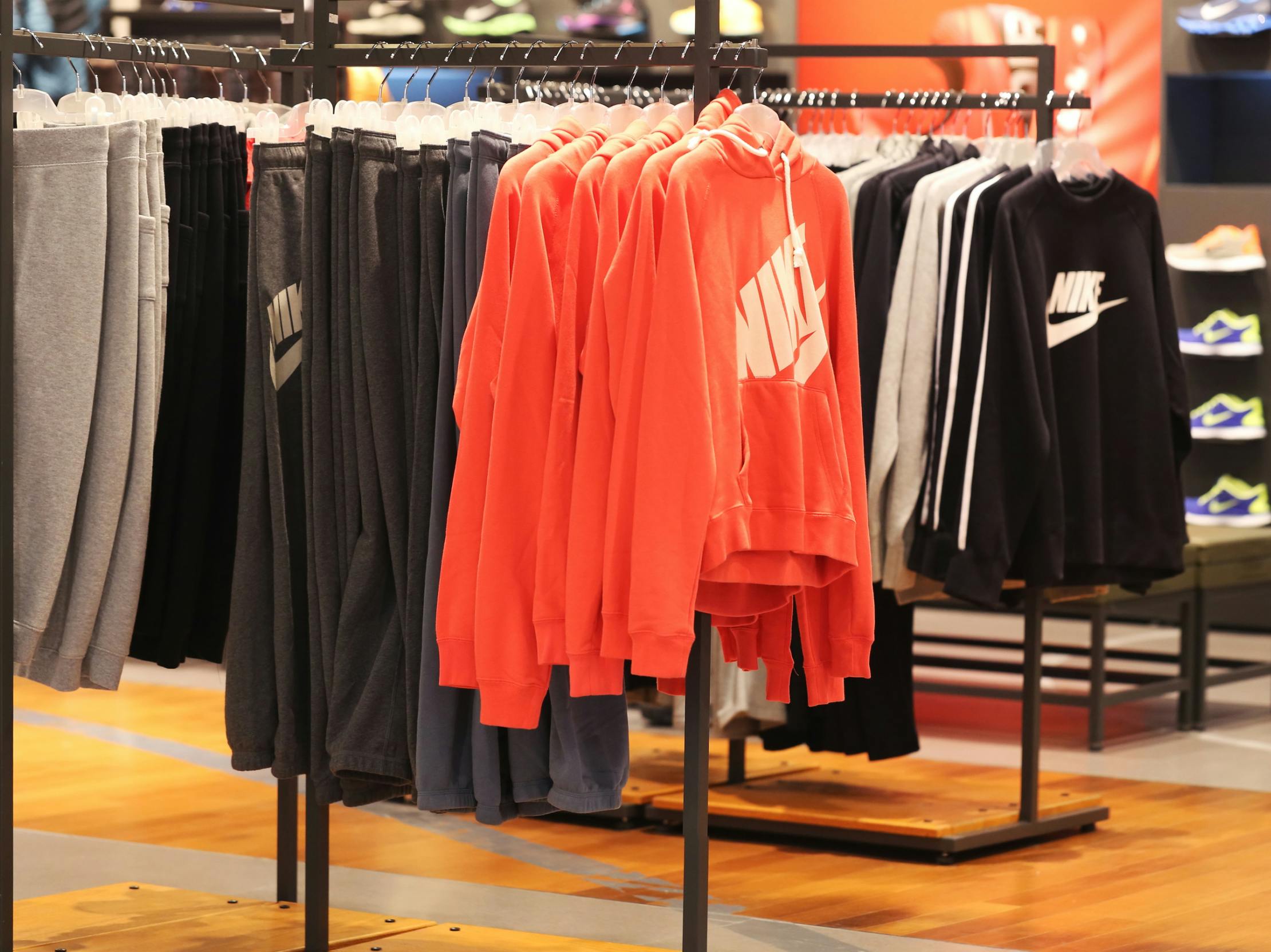 Nike sweatshirts and sweatpants hanging from a rack at the Nike store