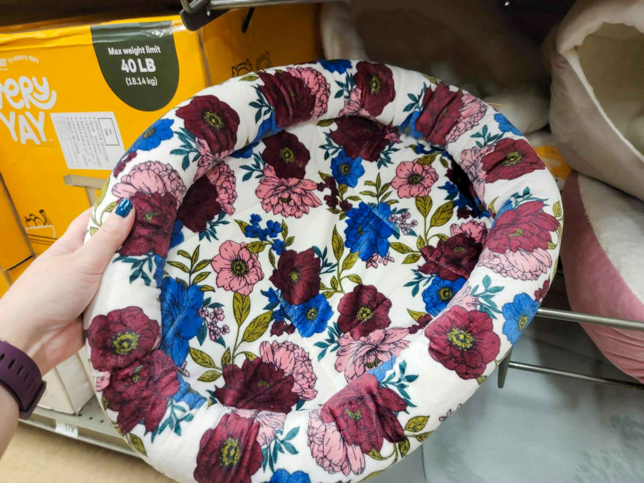 hand holding a floral cat bed