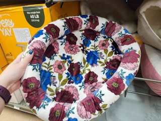 hand holding a floral cat bed