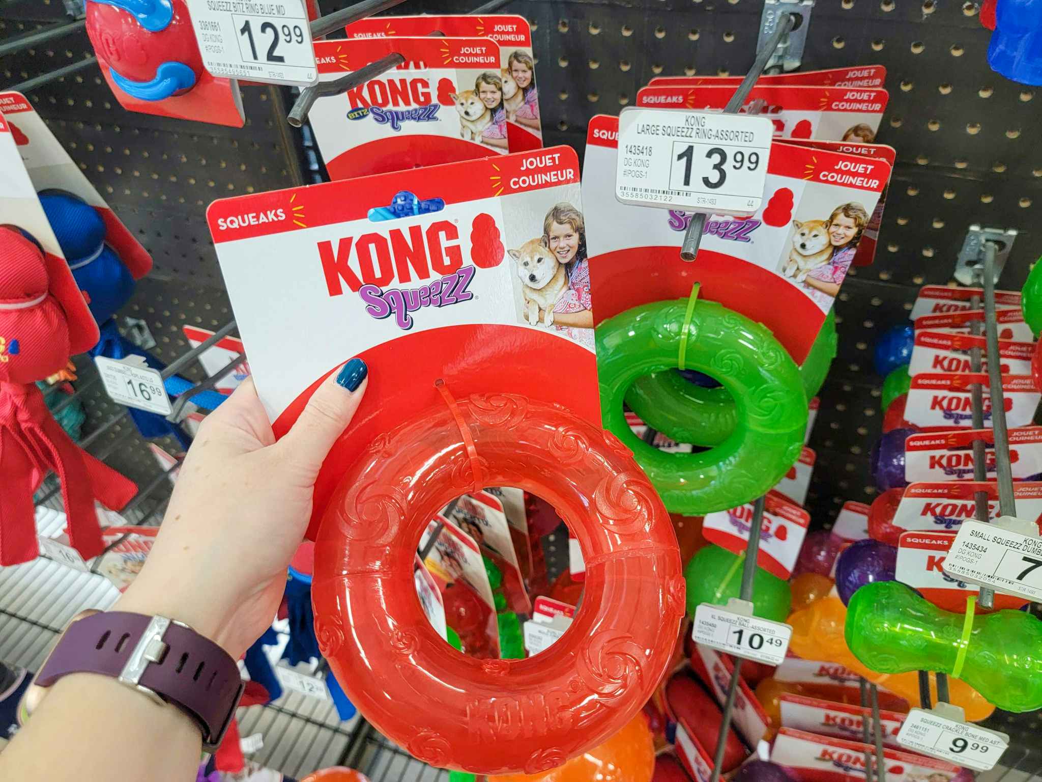 hand holding a red kong ring dog toy