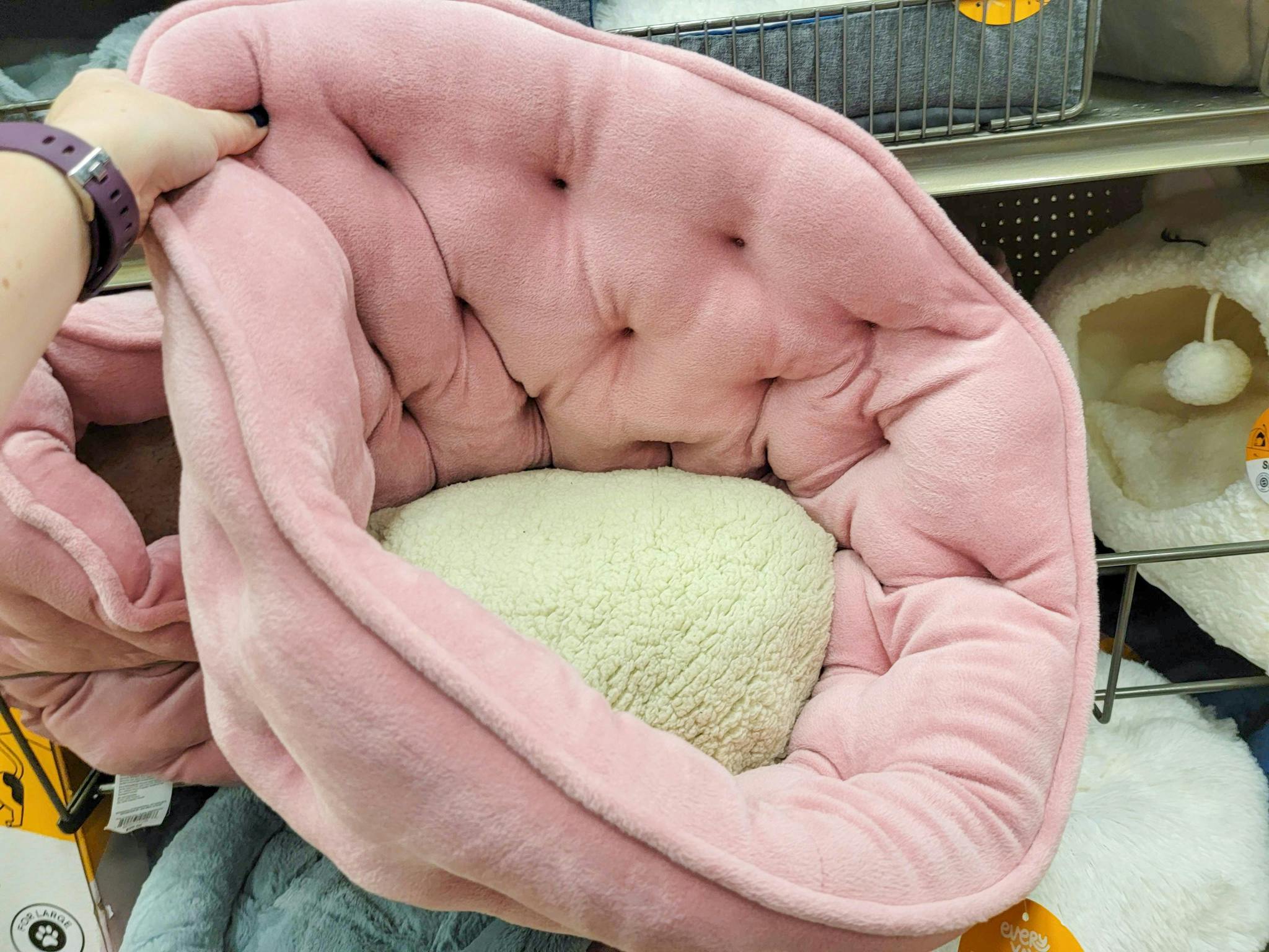 hand holding a pink high back cat bed