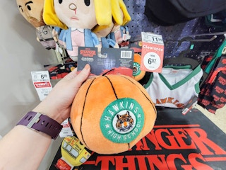 hand holding a hawkins high basketball dog toy from stranger things