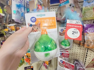 hand holding a treat dispensing cat toy