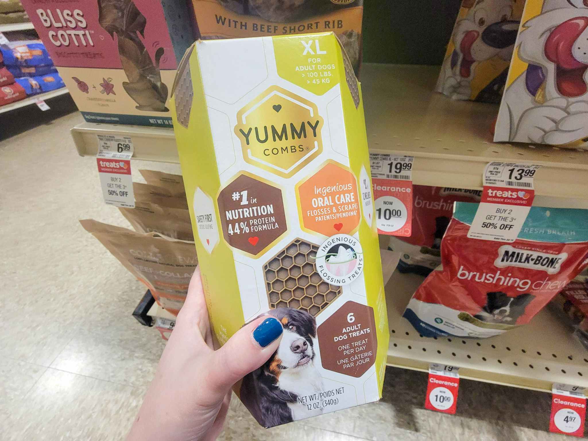 hand holding a box of yummy combs dog treats
