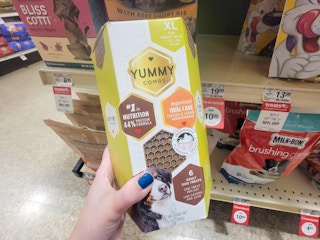 hand holding a box of yummy combs dog treats