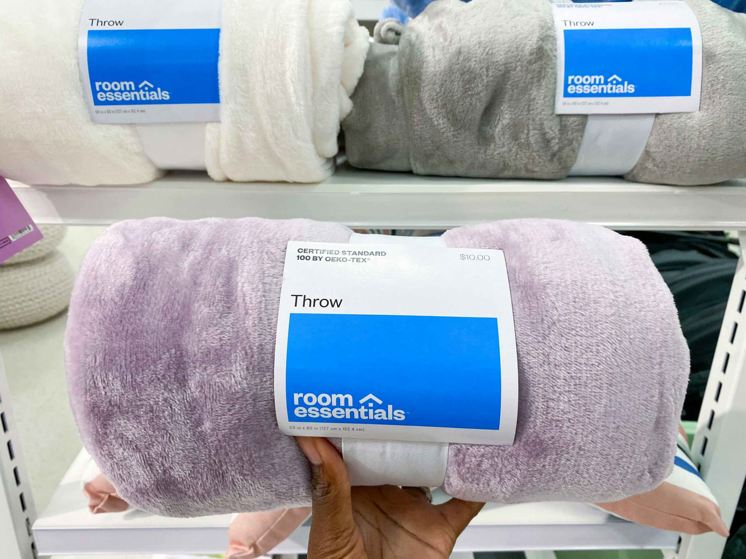 holding up a blanket at Target in the bedding aisle