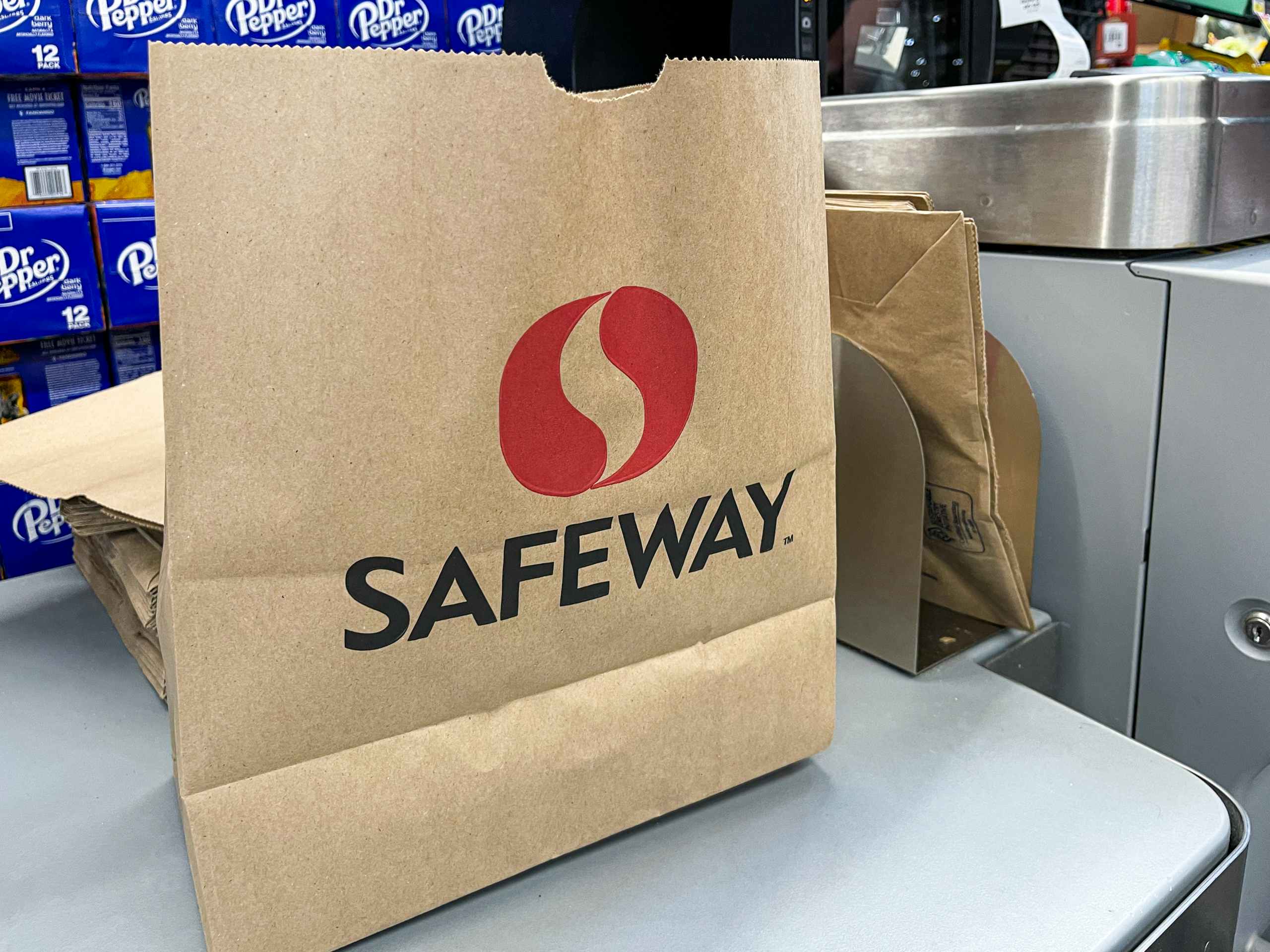 A paper Safeway bag next to the checkout scanner at Safeway.