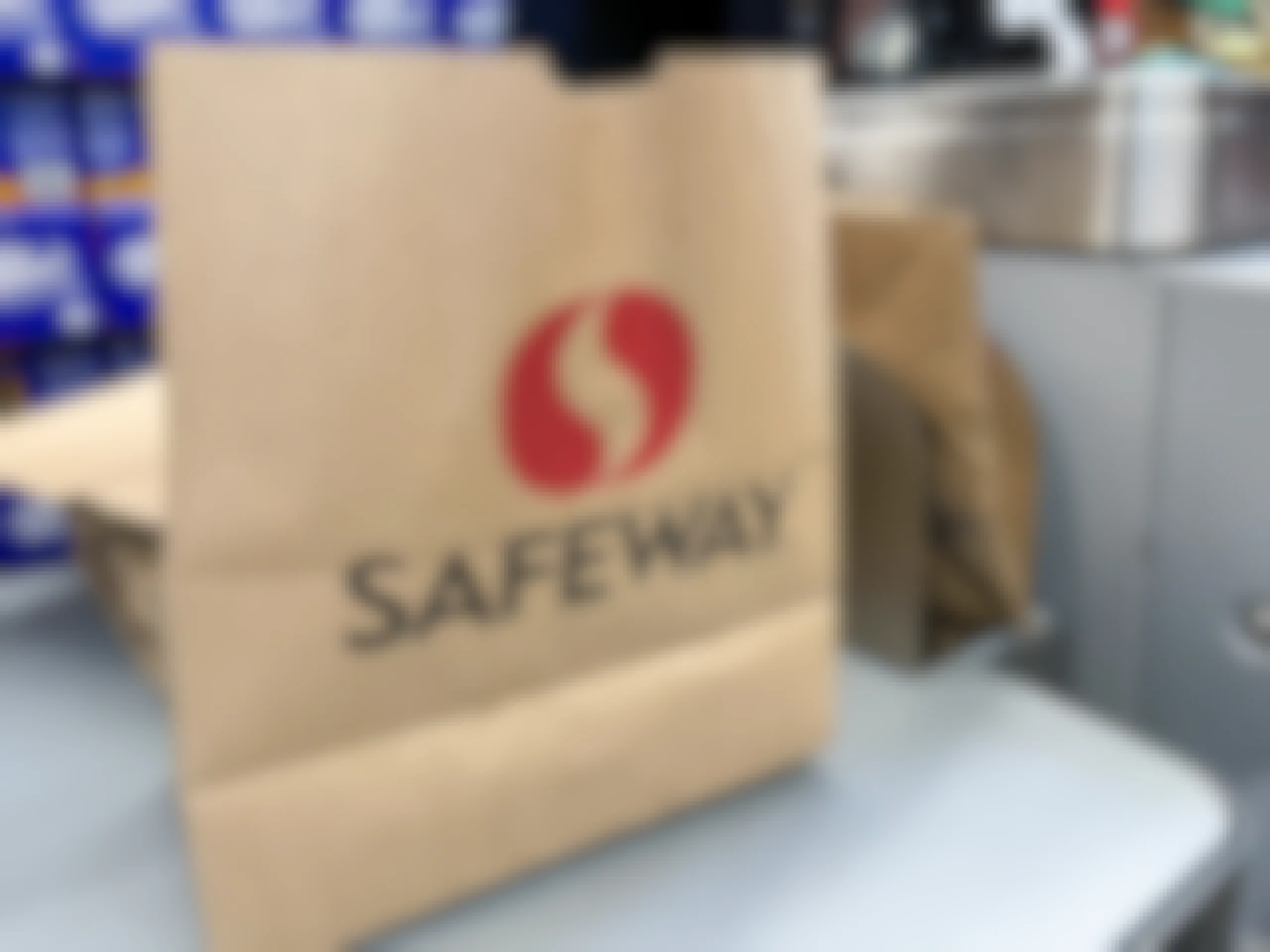 A paper Safeway bag next to the checkout scanner at Safeway.