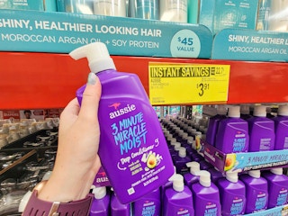 hand holding a large bottle of aussie 3 minute miracle deep conditioner