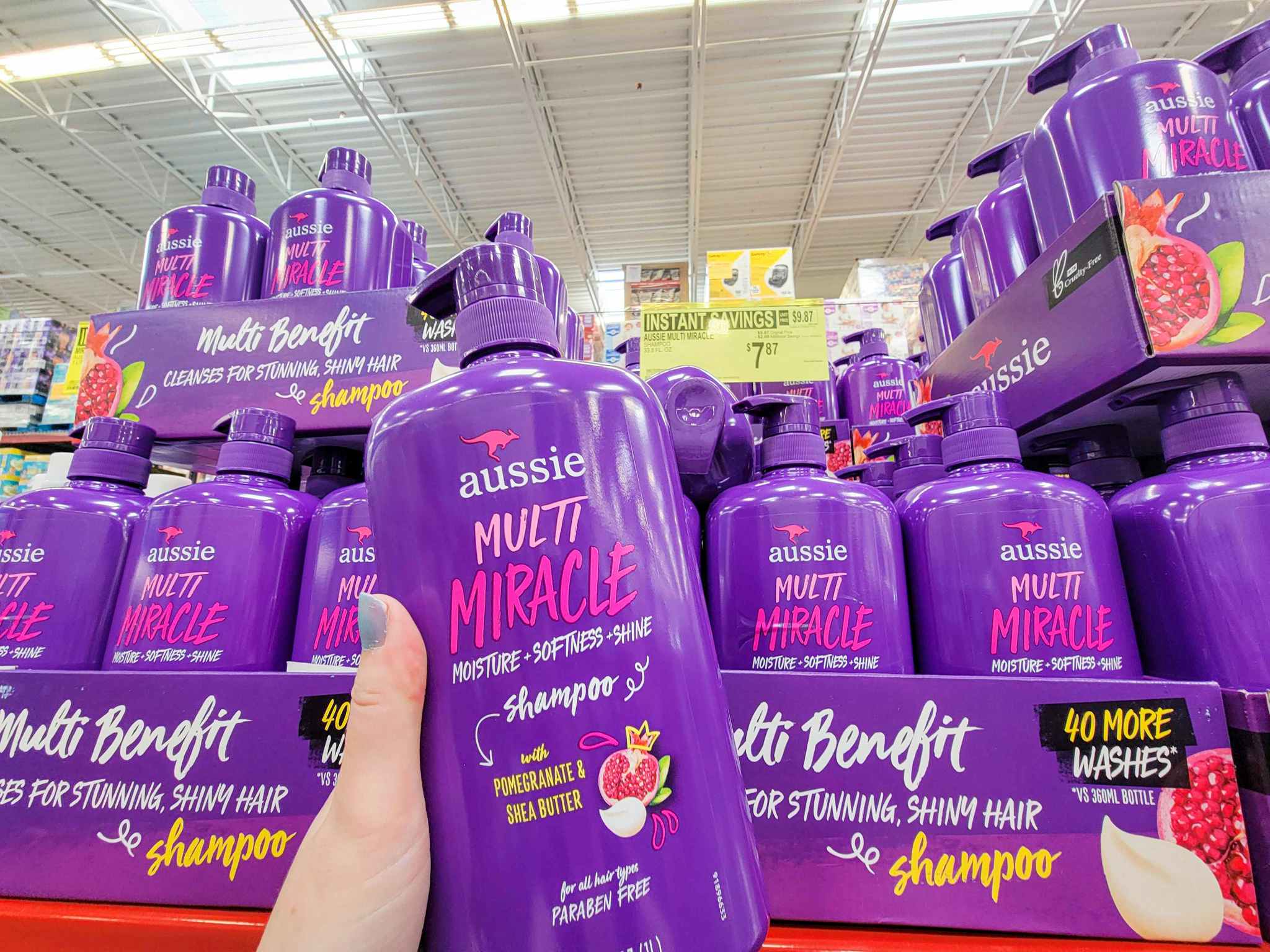 hand holding a large bottle of aussie multi miracle shampoo