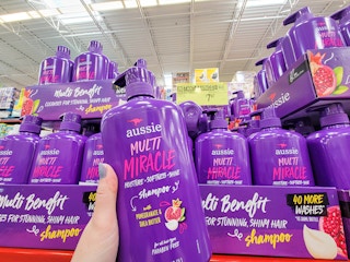hand holding a large bottle of aussie multi miracle shampoo