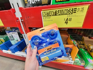 hand holding a pack of 6 white out