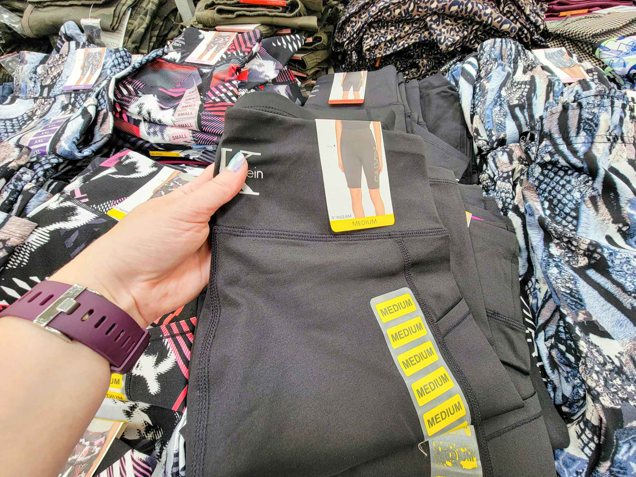 hand holding a pair of black calvin klein ladies bike shorts